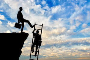 A businessman kicks a ladder that a rival is trying to climb